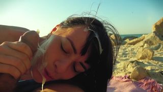 На диком пляже брюнетка дрочит хуй парню и принимает сперму на лицо